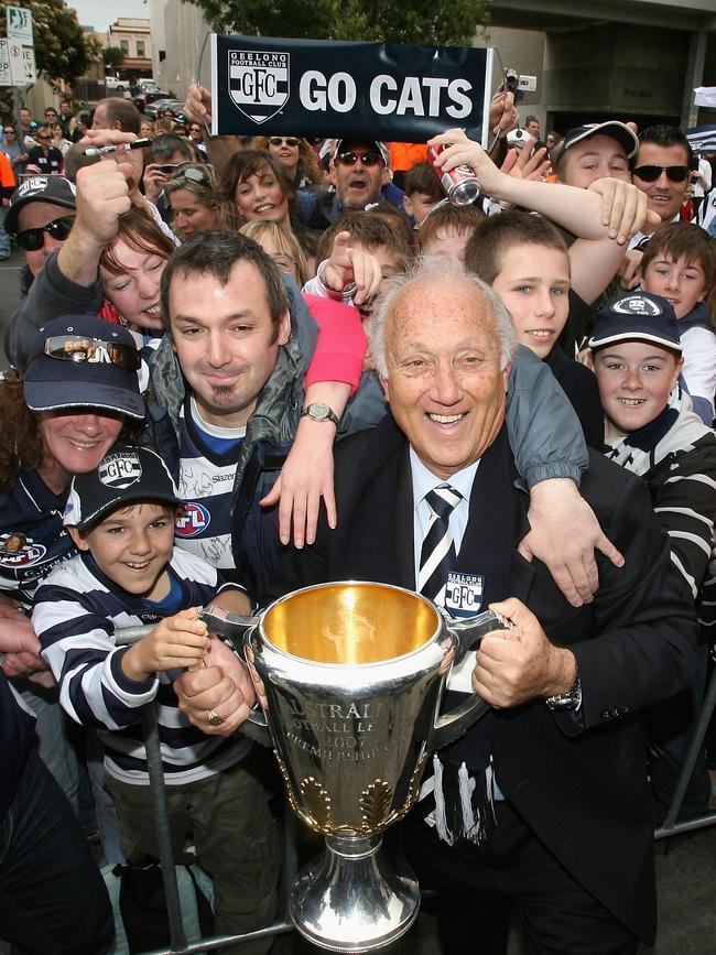 Geelong President, Frank Costa, poses amongst the crowd with the cup during a Geelong Football Club street parade in Geelong.