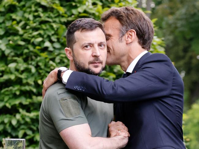 Zelensky, left, and French Fresident Emmanuel Macron embrace after giving a press conference in Kyiv in June.