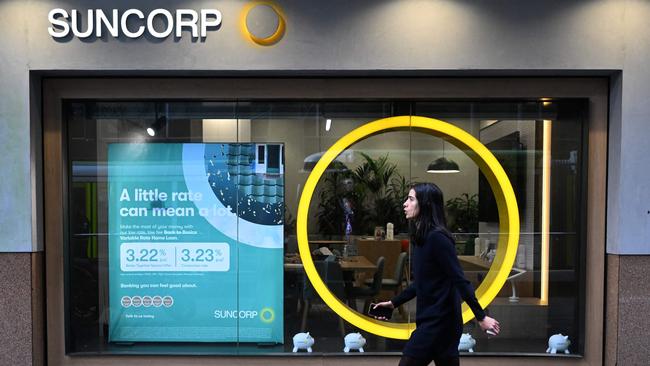 A pedestrian walks past a Suncorp Bank branch in Melbourne on July 18, 2022. - Australian banking giant ANZ announced on July 18 a 3.3 billion USD deal to swallow regional lender Suncorp Bank -- one of the biggest takeovers in the sector for more than a decade. (Photo by William WEST / AFP)