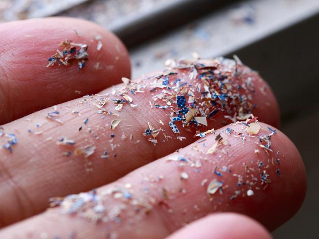 Close up side shot of microplastics lay on people hand.Concept of water pollution and global warming. Climate change idea.