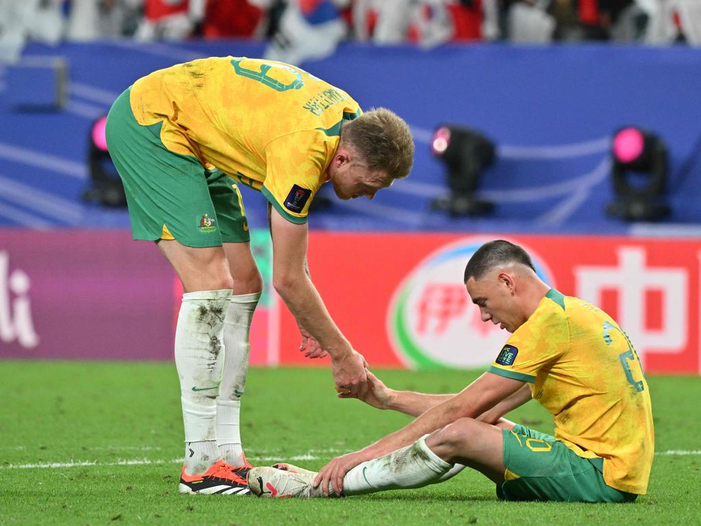 Harry Souttar (left) consoles shattered Socceroos defender Lewis Miller after Australia’s loss to South Korea. Picture: HECTOR RETAMAL / AFP