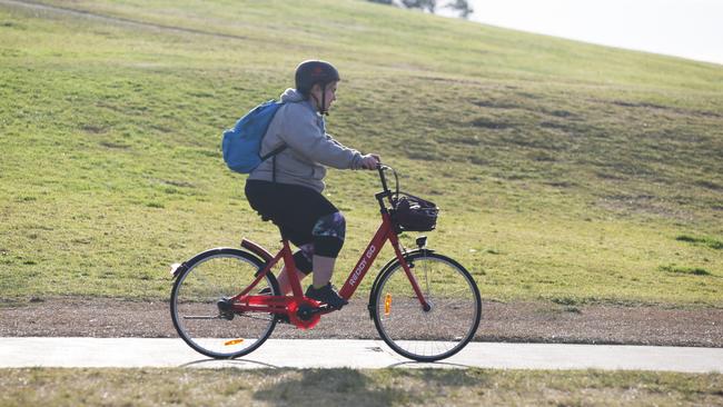 A cyclist riding her bike in Sydney Park, St Peters, Sydney. Photo: AAP