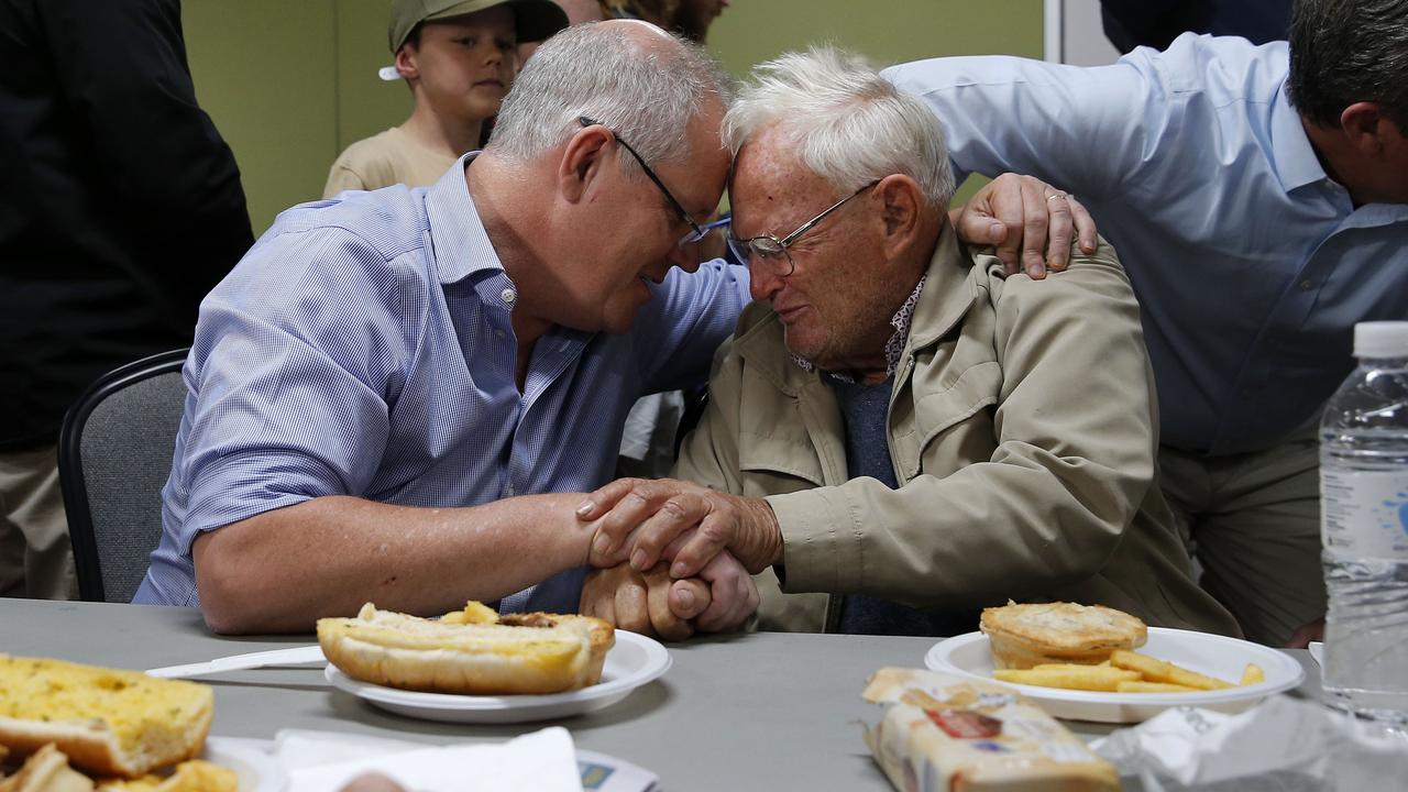 Prime Minister Scott Morrison comforts Owen Whalan, 85, at Club Taree Evacuation Centre on Sunday. Picture: AAP Image/Darren Pateman