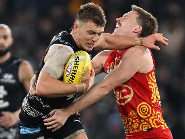 MELBOURNE, AUSTRALIA - MAY 25: Patrick Cripps of the Blues breaks a tackle attempt from Noah Anderson of the Suns during the round 11 AFL match between Carlton Blues and Gold Coast Suns at Marvel Stadium, on May 25, 2024, in Melbourne, Australia. (Photo by Daniel Pockett/Getty Images)