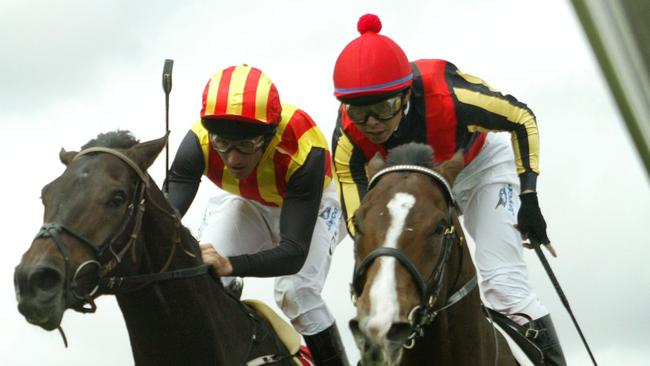 07/11/2006 LIBRARY: Racehorse Delta Blues riden by jockey Yasunari Iwata holds on to win narrowly on the inside from stablemate Pop Rock ridden by Damien Oliver in Race 7, the 2006 Melbourne Cup at Flemington in Melbourne, 07/11/06.