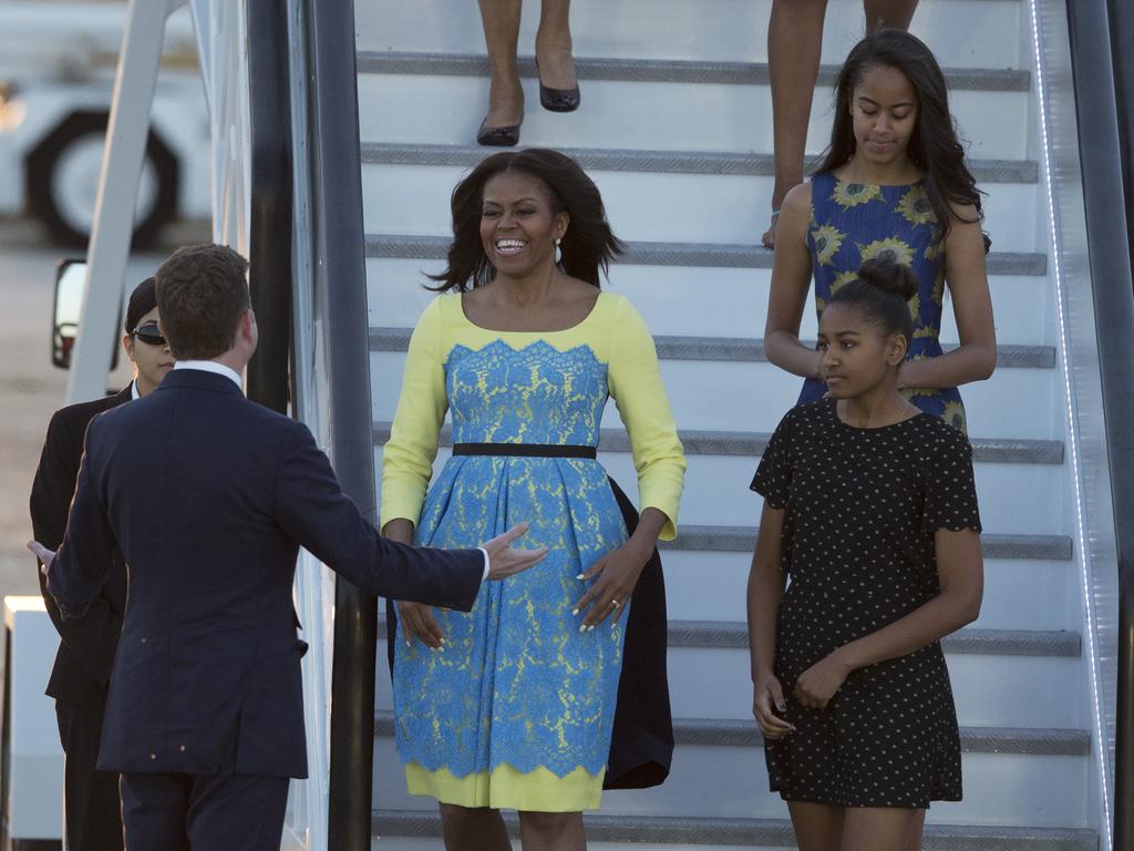 US First Lady Michelle Obama, her daughters Malia, and Natasha, are greeted by U.S, ambassador to the UK Matthew Barzun, left, as they disembark from a plane upon their arrival at Stansted Airport in Stansted, England, Monday, June 15, 2015. Picutre: AAP