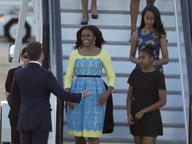 US First Lady Michelle Obama, her daughters Malia, and Natasha, are greeted by U.S, ambassador to the UK Matthew Barzun, left, as they disembark from a plane upon their arrival at Stansted Airport in Stansted, England, Monday, June 15, 2015. Picutre: AAP
