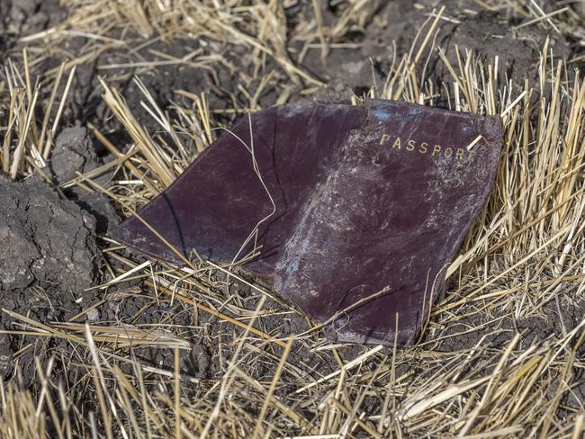 A passenger’s passport lies on the ground at the scene of the crash. Picture: AP 