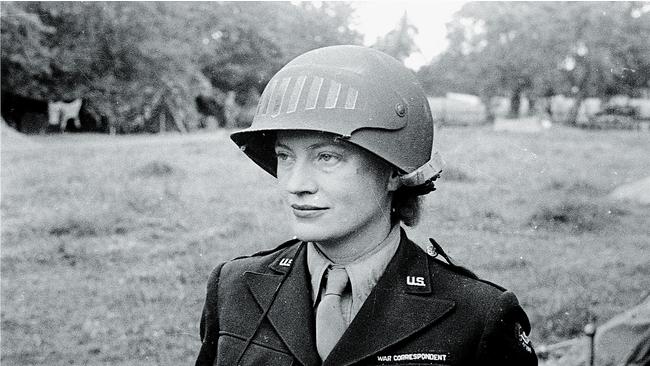 Lee Miller wearing a steel helmet specially designed for using a camera, in Normandy, 1944.