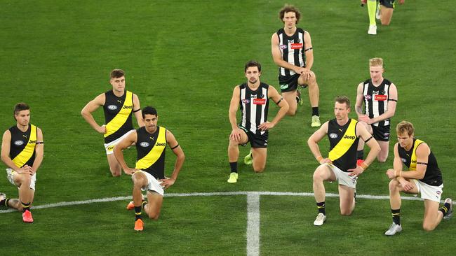 Richmond and Collingwood players kneel before the round 2 AFL match. Picture: Getty Images.