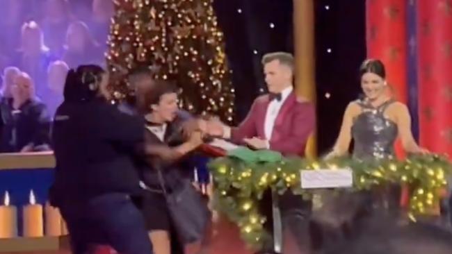 Carols by Candlelight co-hosts David Campbell and Sarah Abo were interrupted by pro-Palestine protesters storming the stage. Picture: @JessicaWestcot8/Twitter