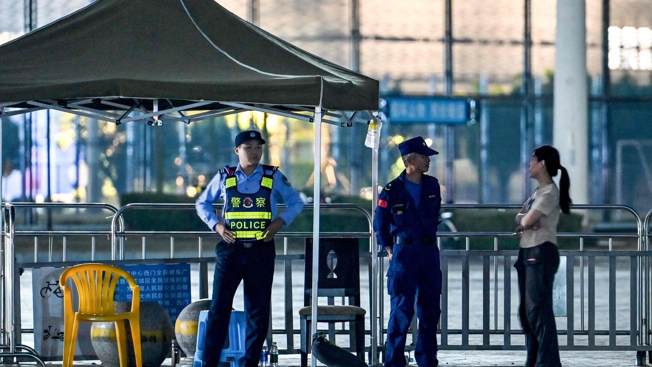 Police stand guard at the Zhuhai Sports Centre, a day after a car rammed through the site. Picture: Hector Retamal/AFP