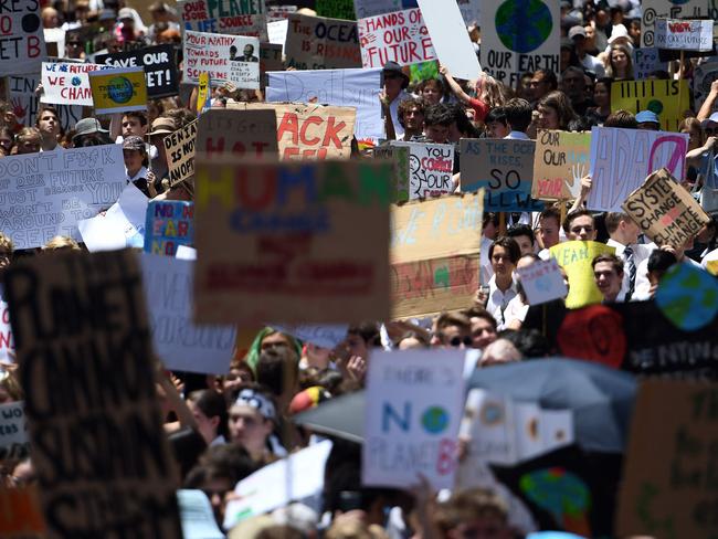 TOPSHOT - Students from different schools raise placards during a protest rally for climate change awareness at Martin Place in Sydney on November 30, 2018. - Thousands of students around the country skipped school today to protest and demand their politicians act urgently to stop further dangerous climate change and the Adani coal mine. (Photo by Saeed KHAN / AFP)