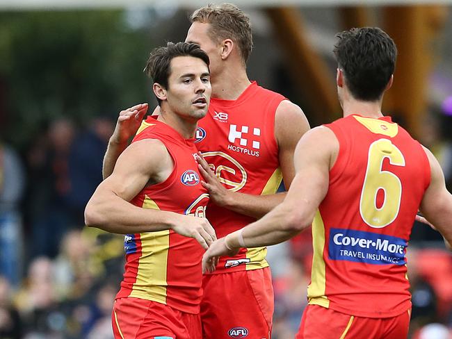 Lachie Weller of the Suns (left) celebrates a goal with teammates during the round 16 AFL match between the Gold Coast Suns and the Richmond Tigers at Metricon Stadium on July 06, 2019 in Gold Coast, Australia. (Photo by Jono Searle/AFL Photos via Getty Images )