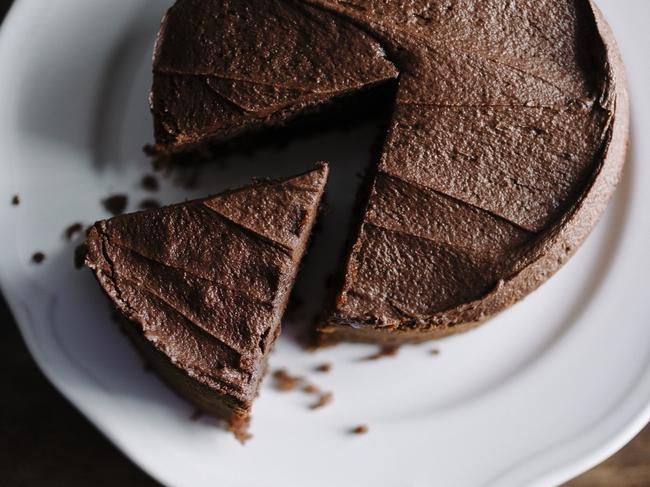 Whole sliced Chocolate cake with slice slightly removed. Photographed in window light with Nikon D800+50mm Zeiss Lens at ISO 100. Image Processed from raw file with VSCO Film Kodak Portra film simulation with film grain for a slightly more lo-fi look.