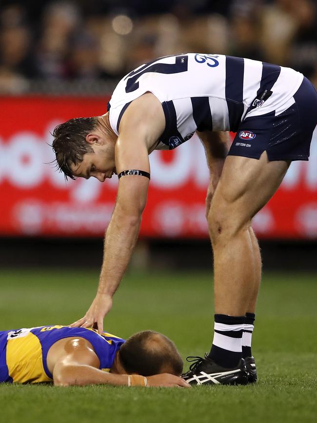 Tom Hawkins checks on Will Schofield after felling him on Friday night. Picture: Dylan Burns/AFL Photos via Getty Images