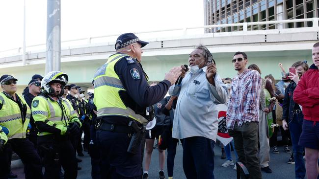 Police talk to a man at a Black Lives Matter protest in Brisbane on Wednesday. Picture: Attila Csaszar