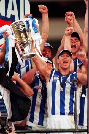 <p>4: WAYNE CAREY. Victorious captain Wayne Carey lifts up the Premiership Cup trophy after the North Melbourne Kangaroos defeat Carlton in the 1999 AFL grand final at the Melbourne Cricket Ground. In 2001 he was named as centre-half forward and captain of North Melbourne's Team of the Century and in 2008 as Australian Football's greatest ever player as part of a list of the top 50 players of all time, published in the book 'The Australian Game of Football'. Picture: Joe Mann</p>