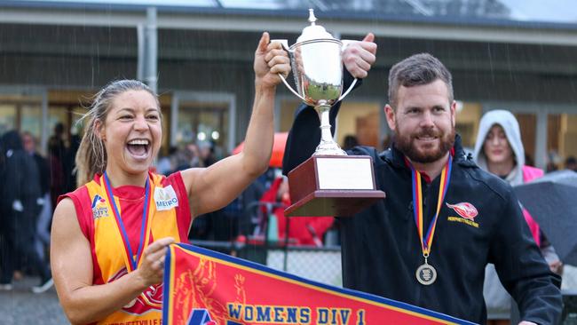 Morphettville Park captain Natalie Hadgecostas and coach Brad Ferrall lift the Adelaide Footy League women's division one premiership cup after triumphing in last year’s grand final. Picture: Brayden Goldspink