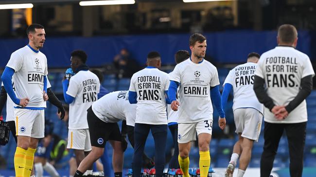 Lewis Dunk and Joel Veltman of Brighton & Hove Albion warm up wearing a t-shirt with a message in protest against the European Super League prior to the Premier League match between Chelsea and Brighton & Hove Albion at Stamford Bridge.