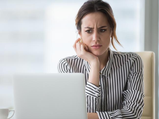 Confused businesswoman annoyed by online problem, spam email or fake internet news looking at laptop, female office worker feeling shocked about stuck computer, bewildered by scam message or virus