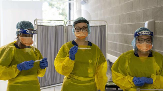 Nurses Joisy Kavalamp, Amanda Fallon and Jade Doliente waiting to pass tests to the admin team for processing. Image Matthew Vasilescu