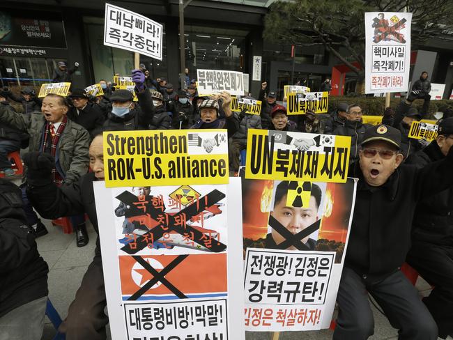 International fury ... protesters in South Korea hold placards with defaced images of North Korean leader Kim Jong-un. Picture: AP Photo/Ahn Young-joon