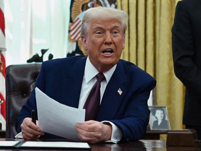 US President Donald Trump speaks in the Oval Office of the White House as he announces reciprocal tariffs, in Washington, DC, on February 13, 2025 as Commerce Secretary Howard Lutnick (R) looks on. Trump announced that he would impose "reciprocal tariffs" on trading partners, opening new fronts in his trade war. The move would match US tariff rates on imports to the levels that other countries impose on US goods. (Photo by ANDREW CABALLERO-REYNOLDS / AFP)