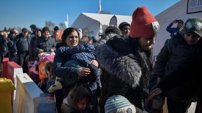 People wait for transportation after crossing the Ukrainian border into Poland. Picture: AFP