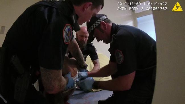 Constable Zach Rofle, left, and fellow NT police officers give first aid to Kumanjayi Walker shortly after he was shot.