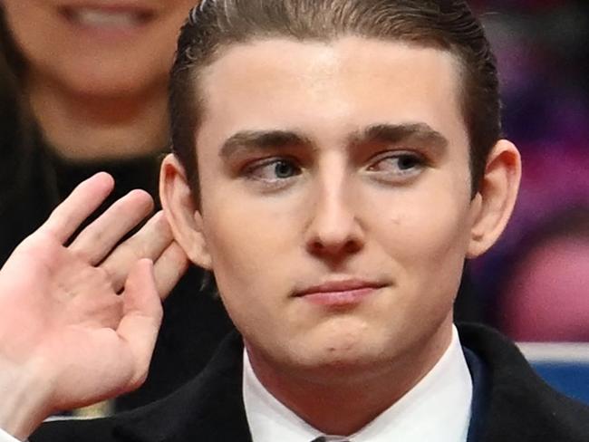 TOPSHOT - Barron Trump gestures after being acknowledged by his father US President Donald Trump during the inaugural parade inside Capital One Arena, in Washington, DC, on January 20, 2025. (Photo by ANGELA WEISS / AFP)