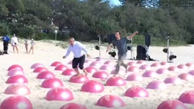 It all starts off okay for Gold Coast Mayor Tom Tate (left) as he tackles the inflatable balls. Pic: ABC Gold Coast