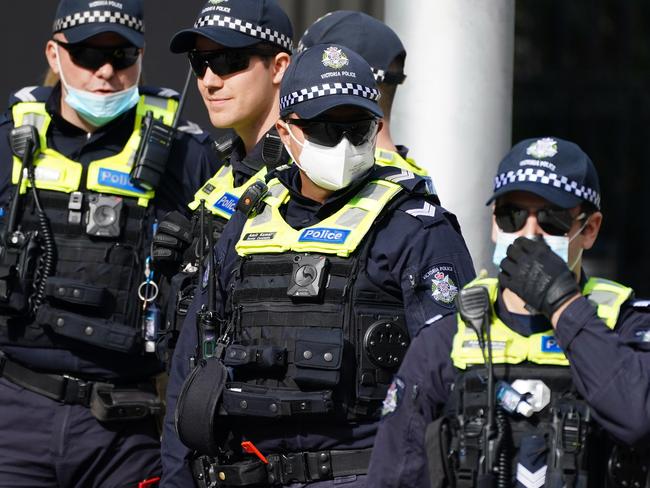 Police officers look on as protesters gather outside Parliament House in Melbourne, Sunday, May 10, 2020. Anti-vaxxers and Victorians fed up with the coronavirus lockdown have broken social distancing rules to protest in Melbourne's CBD on Mother's Day. (AAP Image/Scott Barbour) NO ARCHIVING