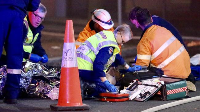 The man being treated by paramedics on the road. Picture: Steve Tyson