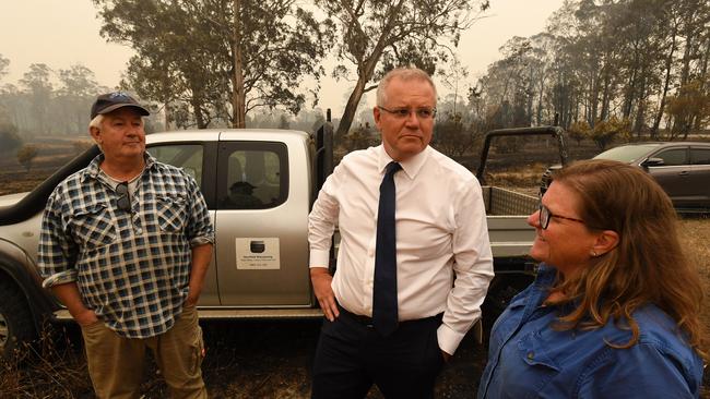 Prime Minister Scott Morrison (left) speaks with Paul and Melissa Churchman at their destroyed wildflower farm Sarsfield, Victoria.