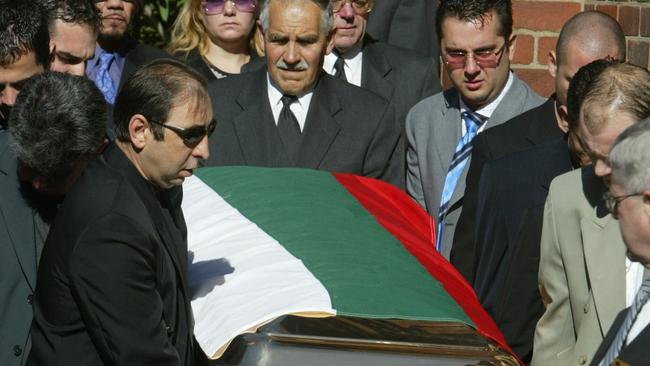 Mourners carry Nik Radev’s gold casket from the church.