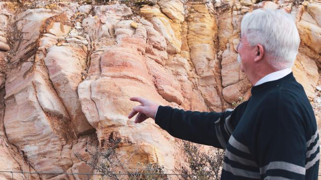 Leon Faulkner describing the natural seams in the rock at Kapunda which would allow a solution to flow through it. Picture: Jason Katsaras