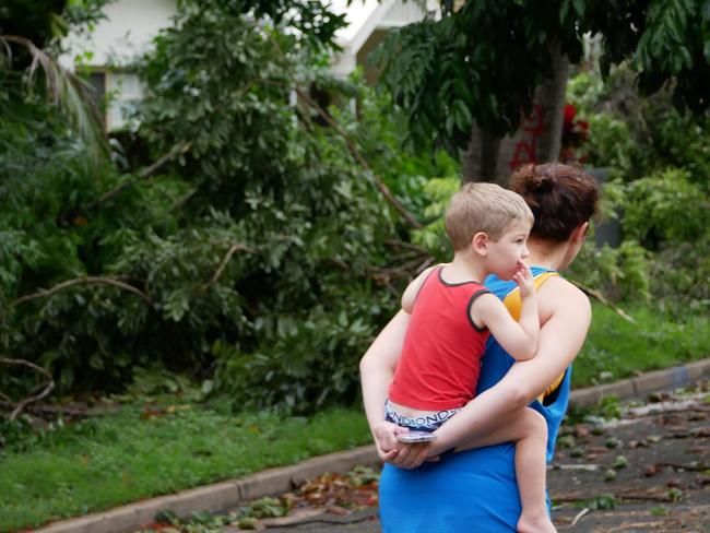 Tropical Cyclone Kirrily 2024: A mother and son survey damage to gardens at houses and the primary school on Potts Street, Belgian Gardens.