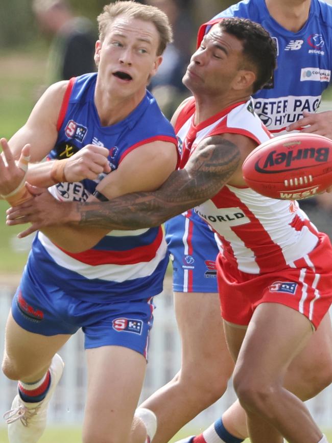 Central District’s Mani Liddy handballs under pressure from North Adelaide’s Frank Szekely at Elizabeth Oval on Friday. Picture: SANFL Image/David Mariuz.