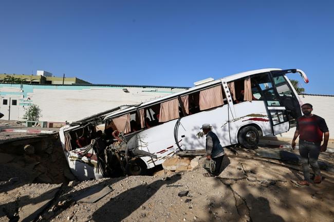 An Israeli air strike in the south Gaza city of Khan Yunis leaves a crater that pulls in a bus.