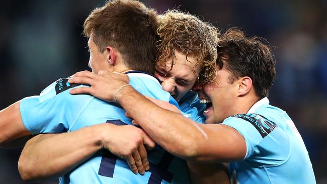 Waratahs players (l-r)Alex Newsome, Ned Hanigan and Nick Phipps celebrate the win on Saturday night.