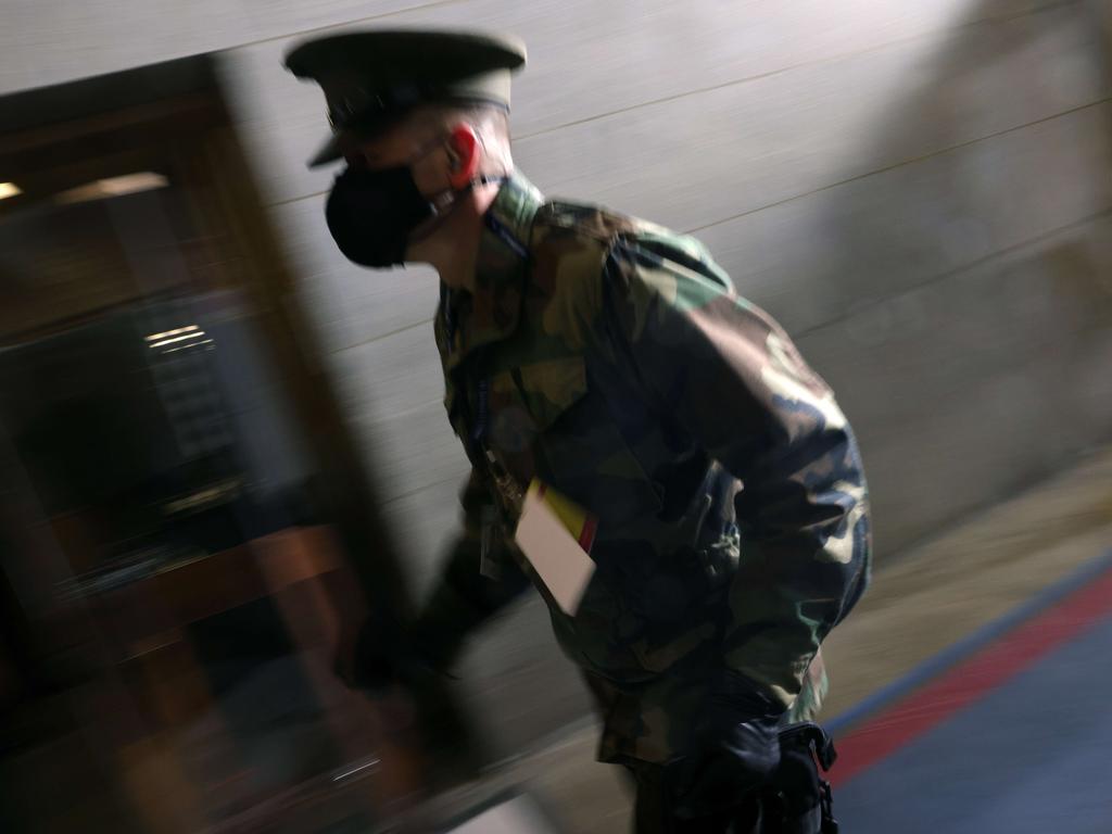 A member of the military rushes past as people are evacuated back inside during a rehearsal for Joe Biden’s inauguration. Picture: Getty Images/AFP