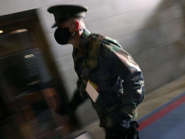 A member of the military rushes past as people are evacuated back inside during a rehearsal for Joe Biden’s inauguration. Picture: Getty Images/AFP