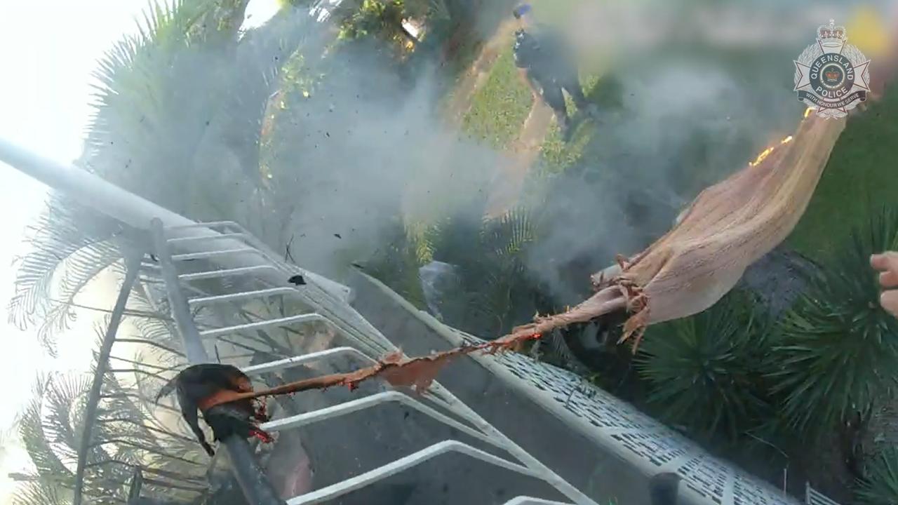 Constable Alexander Campbell of Ingham Police tosses a burning cushion from a burning rattan couch from the second storey of a home during a dramatic incident recently. Picture: Supplied