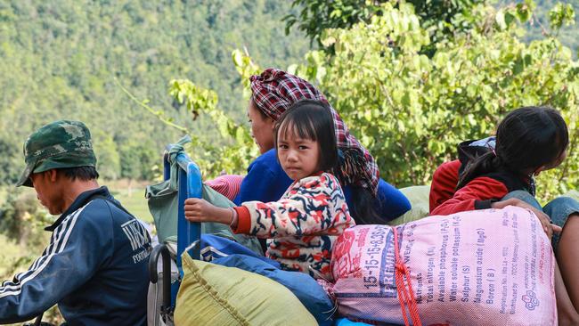 This picture taken on December 9, 2024 shows displaced people transporting belongings at an internally displaced persons camp (IDP) in Pekon township in Myanmar's Shan State. Residents from Hwari Suplai in Moe Bye township moved to the IDP camp after Myanmar's military started offensives near their village. (Photo by AFP)