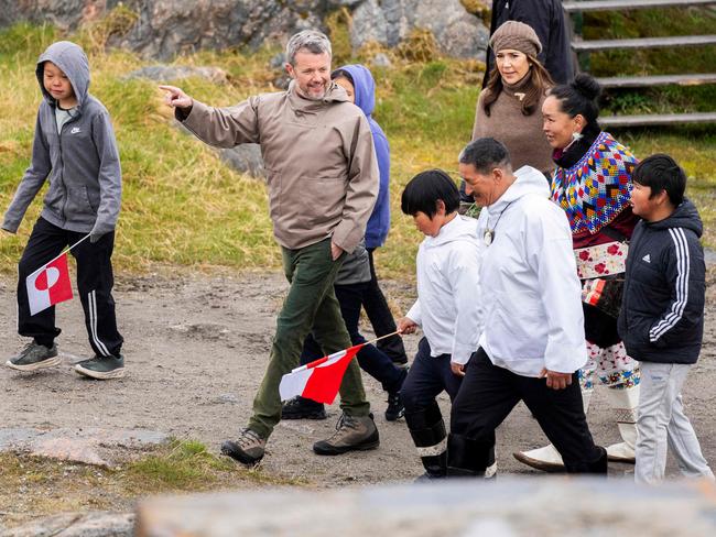 Danish King Frederik X and Queen Mary are accompanied by the chairman of the village council Per Ole Frederiksen and Karen Alaufesen, who grew up in the town, during a visit in Attu in Greenland. Picture: AFP / Denmark OUT