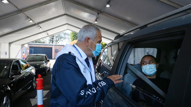 Dr. Jamal Rifi speaks with a client prior to administering a vaccine on the weekend. Picture: Lisa Maree Williams/Getty Images)