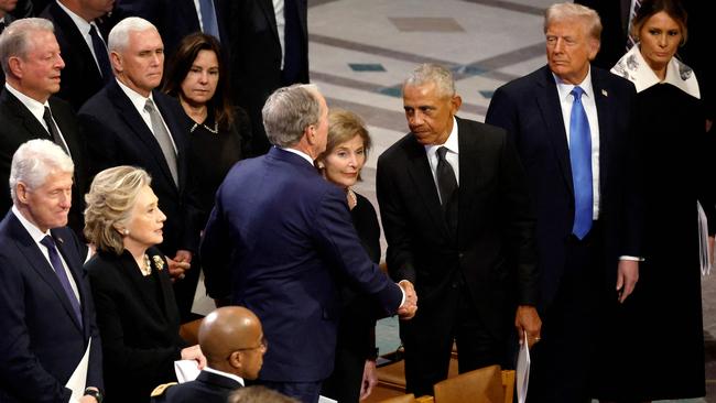 Barack Obama greets George W. Bush (centre) following the state funeral. Picture: Getty Images via AFP