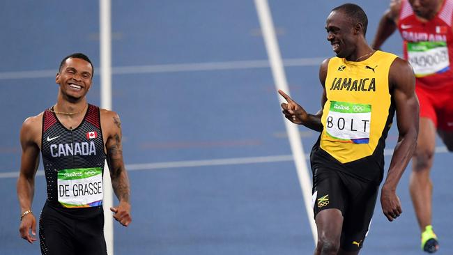 Usain Bolt  (right) jokes with Andre De Grasse as they finish their 200m semi-final at the Rio Olympics. De Grasse is out of the world championships in London with a torn hamstring.