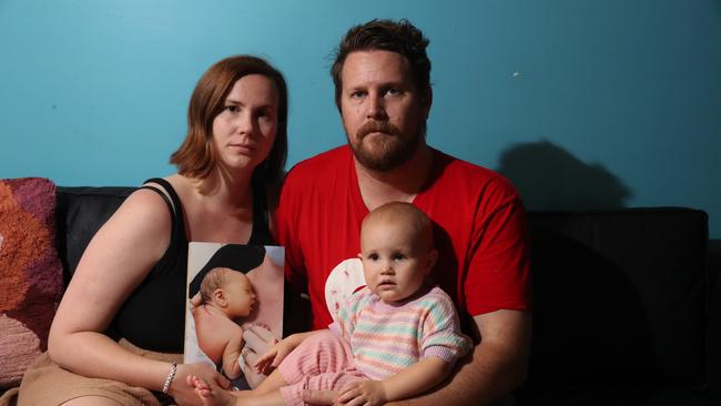 A Gold Coast mum lost her infant son due to a heart defect, three weeks later, they lost everything in the Qld floods. Lonni and Asleigh Mahony with their 16 month old daughter Tully and a photo of Sidney. Picture Glenn Hampson